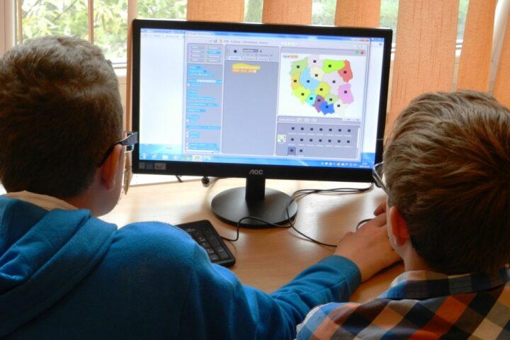 Due bambini davanti al display di un computer