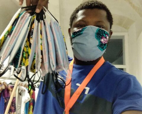 Un ragazzo dello Siproimi/Sprar di Matera mostra le mascherine realizzate nel laboratorio del centro di accoglienza