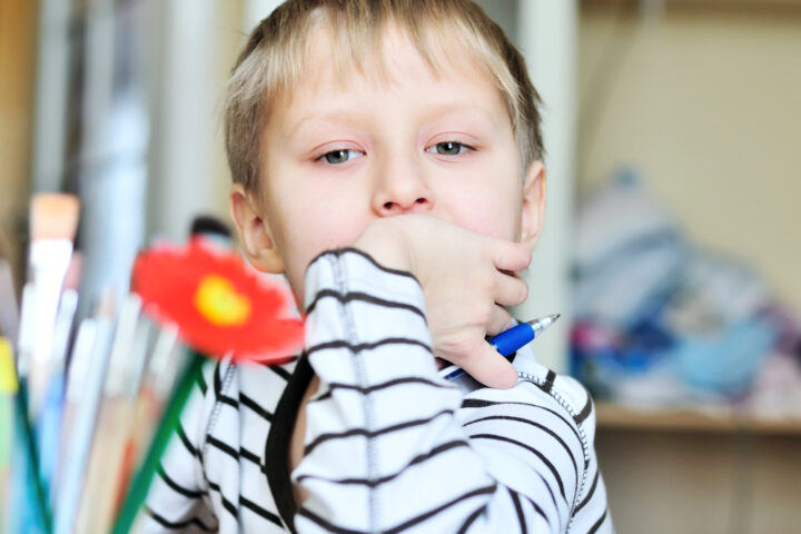 Un bambino mancino tiene la penna nella mano sinistra