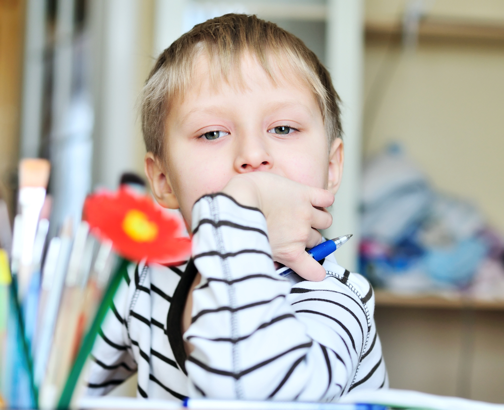 Un bambino mancino tiene la penna nella mano sinistra