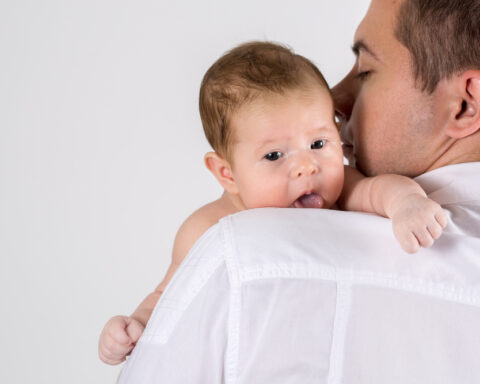 Un papà bisbiglia all'orecchio del suo bambino