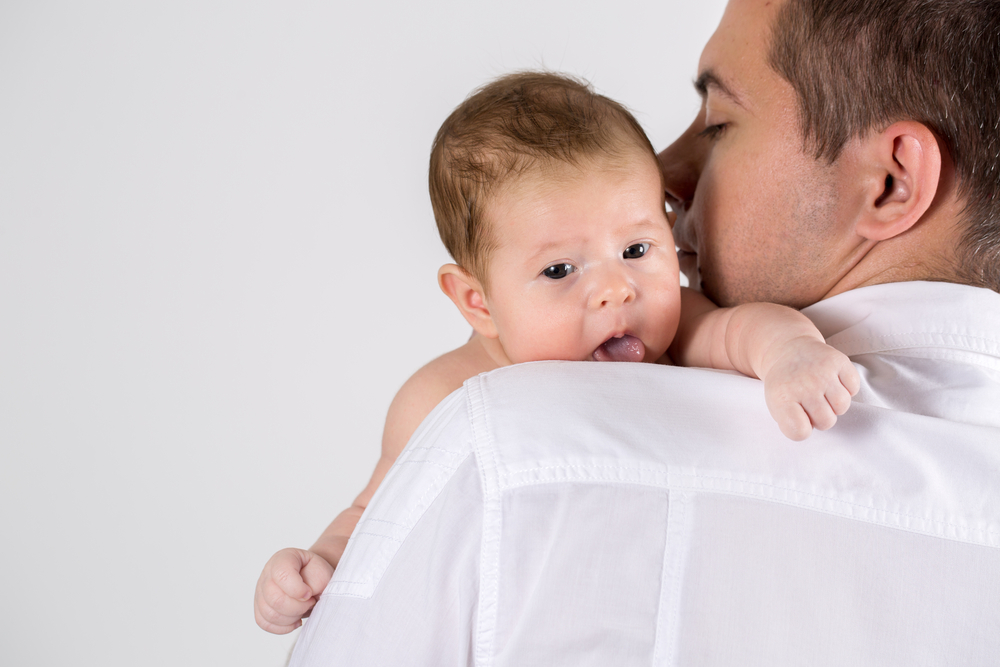 Un papà bisbiglia all'orecchio del suo bambino