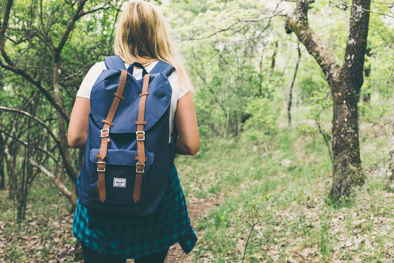 Una ragazza con uno zaino durante un'escursione in un bosco