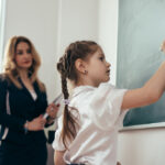 Una bambina di scuola primaria alla lavagna