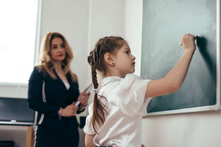 Una bambina di scuola primaria alla lavagna