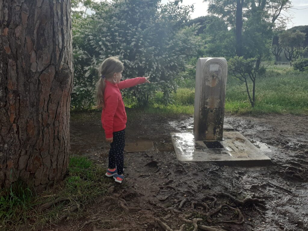 Una bambina davanti ad una fontanella di Villa Pamphili, storica villa di Roma