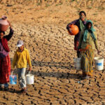 persone che portano acqua in territorio colpito da siccità