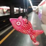 Un Pescefancù ciondolo in primo piano, sullo sfondo una stazione della metropolitana