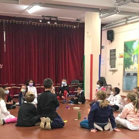 Un'operatrice pedagogico-teatrale con i bambini in un teatro