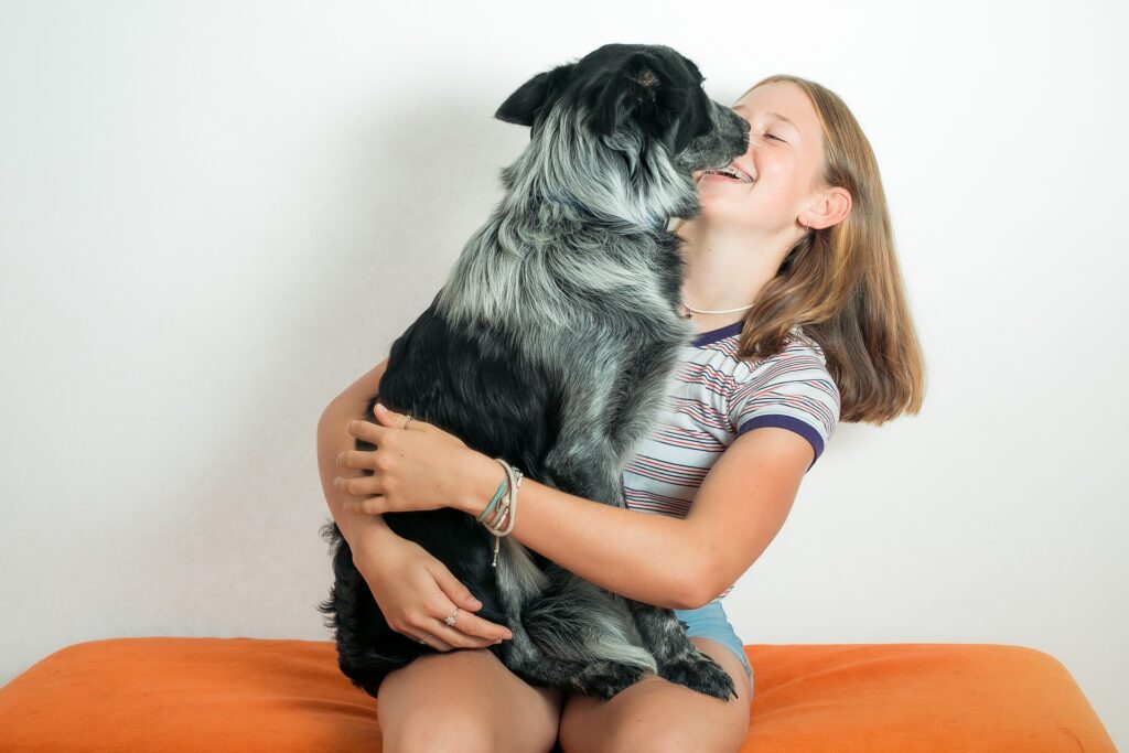 Una ragazza abbraccia il suo amico cane