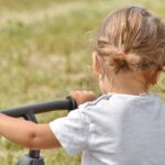 Una bambina di spalle nel verde