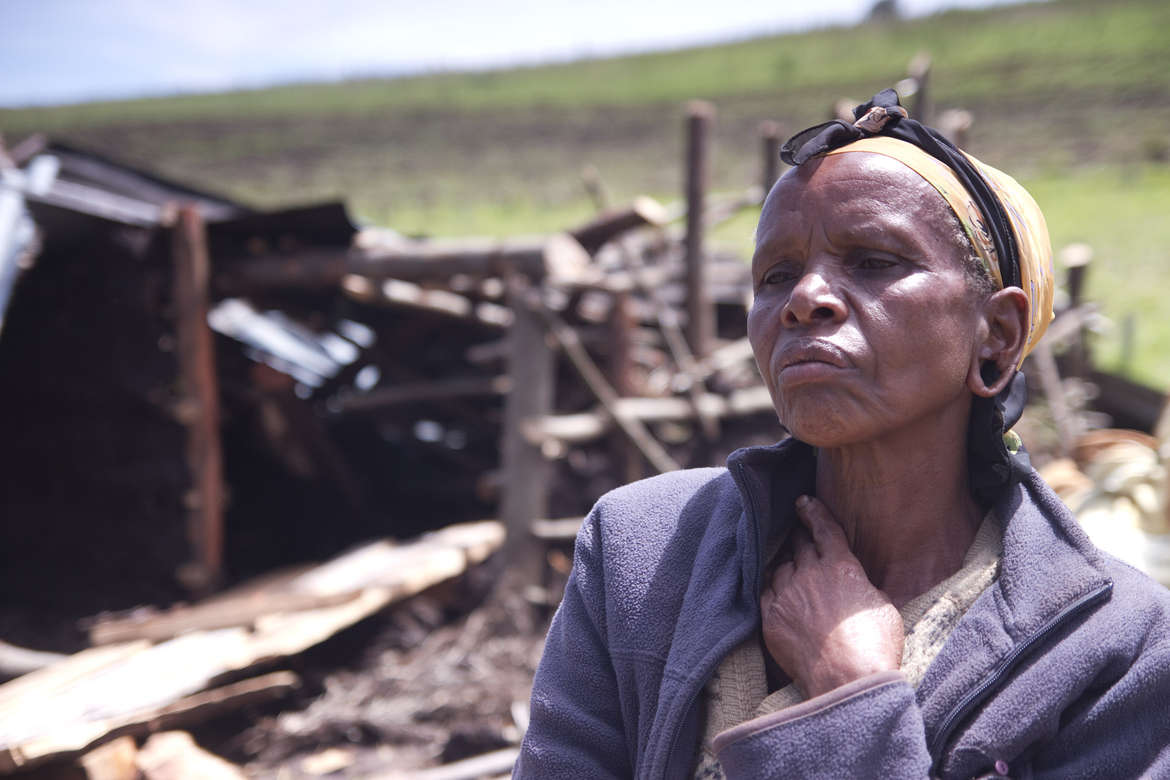 Elisabeth Tabinoy, donna Ogiek, di fronte ai resti della sua casa, abbattuta e bruciata durante un precedente sfratto. Ngongeri, Njoro, Kenya. © Lewis Davies/Survival