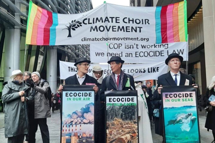 Un coro dei Climate Choir Movement in azione nel dicembre 2023, alla City di Londra. I partecipanti indossano le iconiche bombette