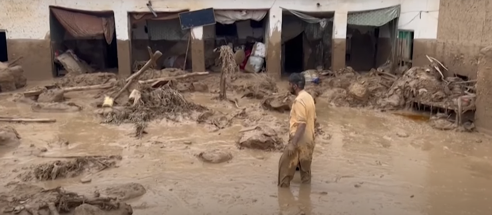 Un uomo in mezzo a un terreno alluvionato in Afghanistan