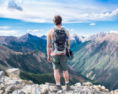 Un ragazzo contempla un paesaggio montano dopo un'escursione