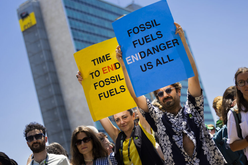 L'azione di protesta dei movimenti per il cima sotto la sede dell'Eni a Roma