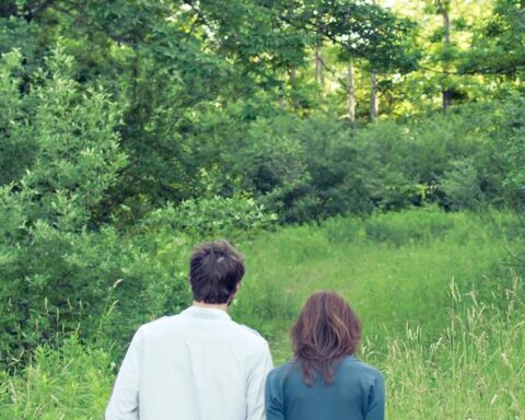 un uomo e una donna di spalle circondati da piante