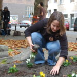 Una donna mentre fa guerrilla gardening in una città occidentale