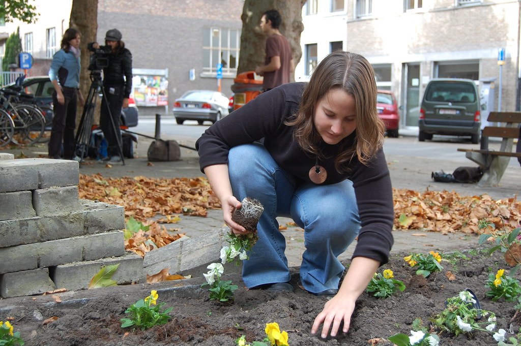 Una donna mentre fa guerrilla gardening in una città occidentale