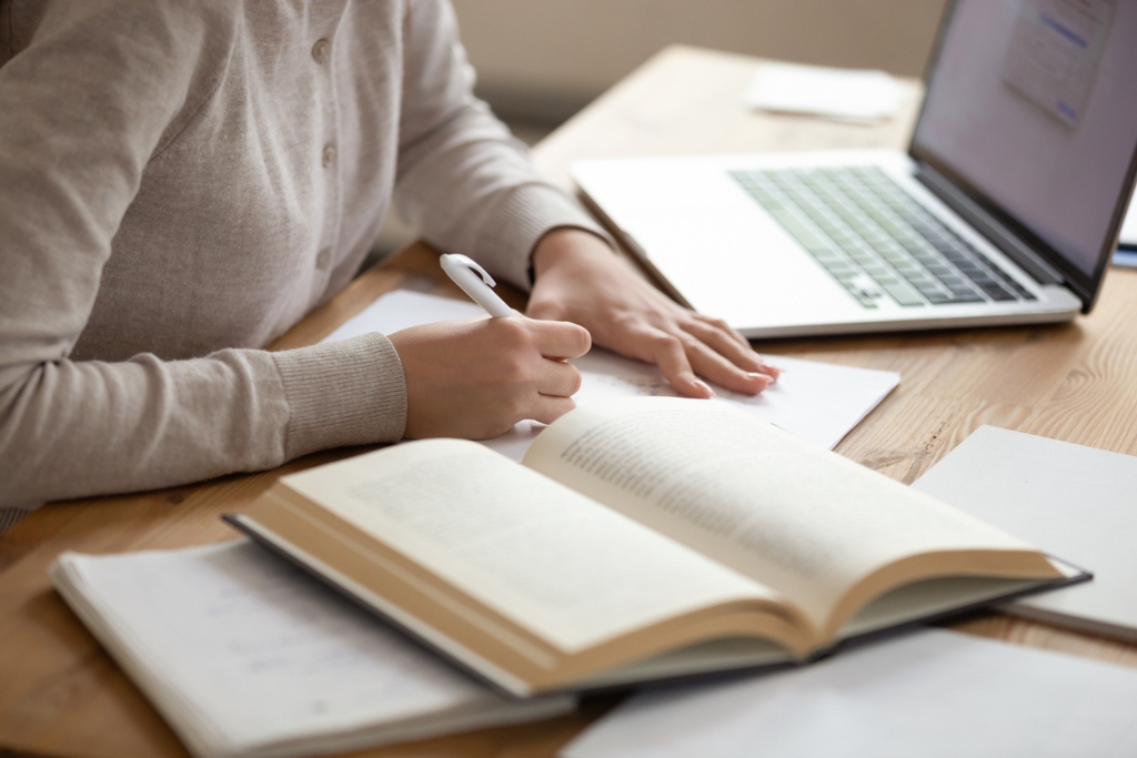 Latino sì, latino no: una ragazza studia con i libri e il computer