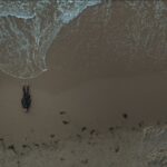 “Breath”, il docufilm che racconta la bellezza e la sofferenza del mare: un uomo sulla battigia inquadrato dall'alto