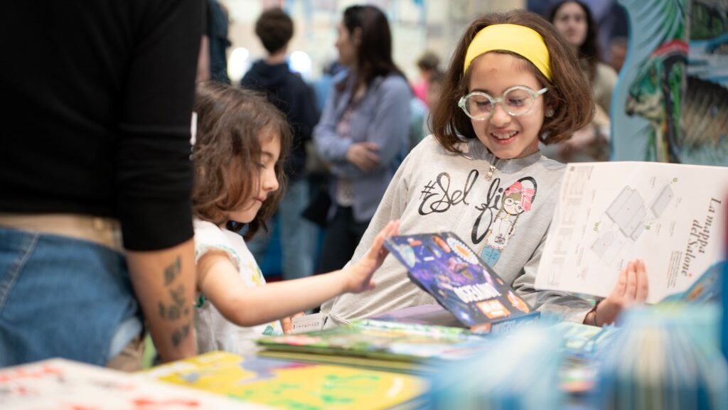 Salto25 è un successo ma l'editoria cala: bambini in uno stand di libri