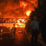 Teheran, Iran. 15 giugno 2025. Gli iraniani, che si guardano come un pennacchio di fumo pesante e fuoco, si alzano da una raffineria di petrolio a Teheran, dopo essere stati colpiti da un attacco israeliano durante la notte, domenica 15 giugno 2025.