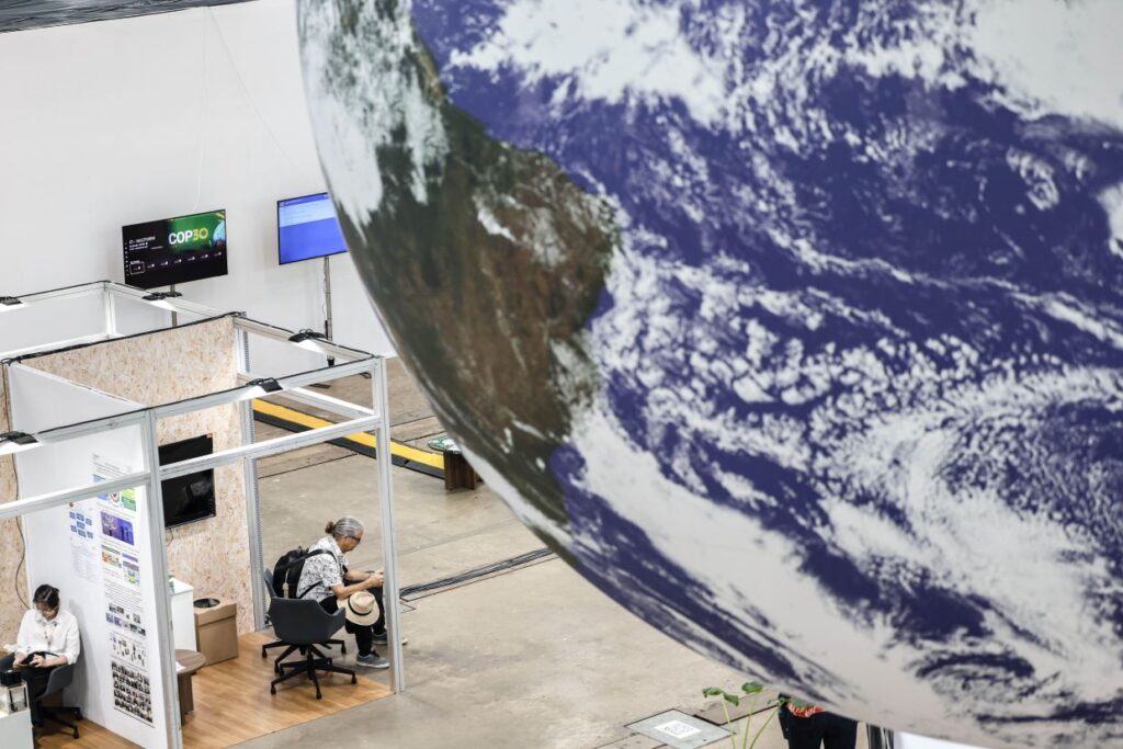 Un partecipante alla Cop30 sotto un'installazione nell'area di lavoro.