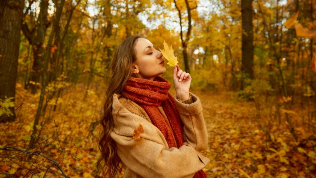 Cinque fenomeni dell'autunno che dovete conoscere: una ragazza sente il profumo di una foglia