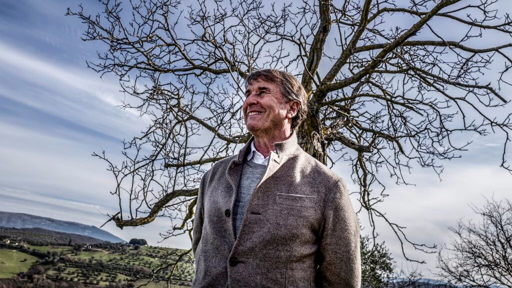 Tornatore racconta Cucinelli: Brunello Cucinelli sorridente sotto un albero spoglio