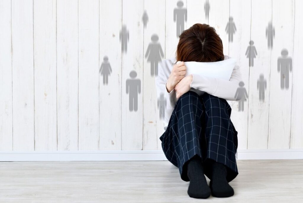 ragazzino rannicchiato nasconde il viso