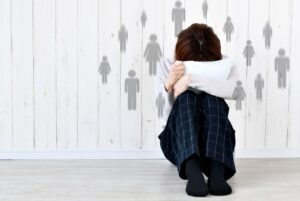 ragazzino rannicchiato nasconde il viso