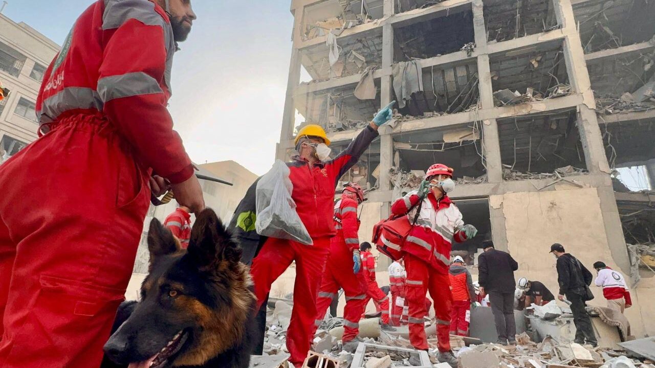 Squadre di soccorso della Mezzaluna Rossa iraniana al lavoro intorno a un edificio danneggiato da un attacco aereo. Teheran