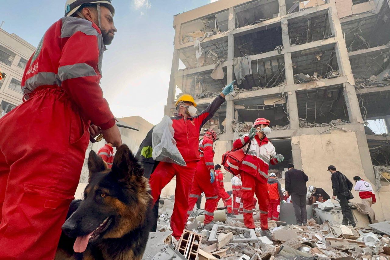 Squadre di soccorso della Mezzaluna Rossa iraniana al lavoro intorno a un edificio danneggiato da un attacco aereo. Teheran
