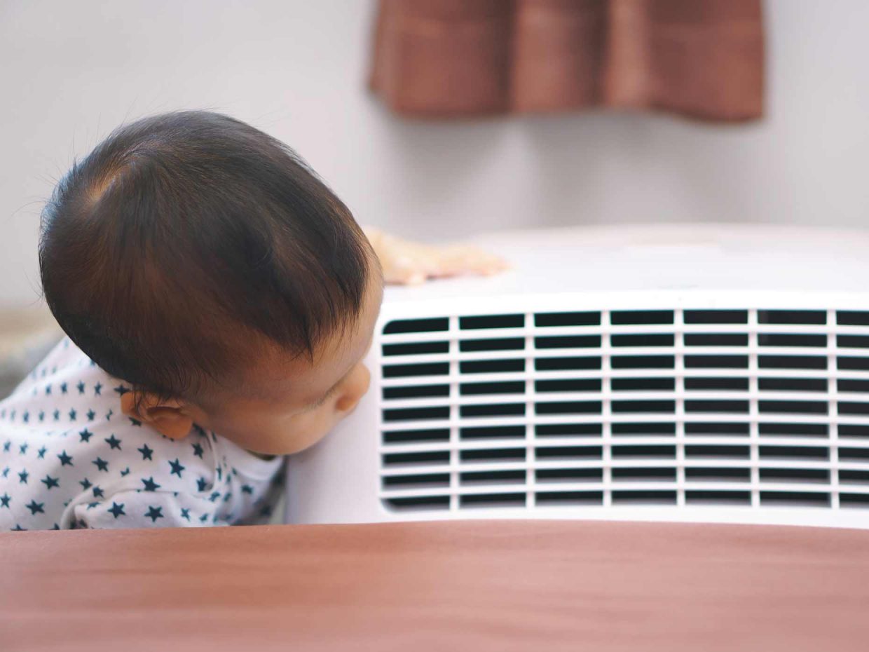 Un bambino accanto a un condizionatore d'aria