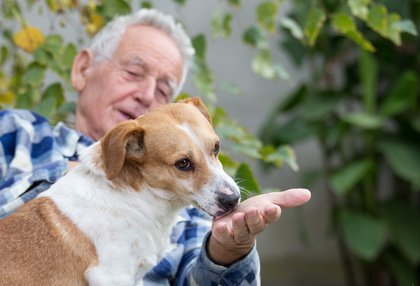 Un anziano all'aperto con il proprio cane