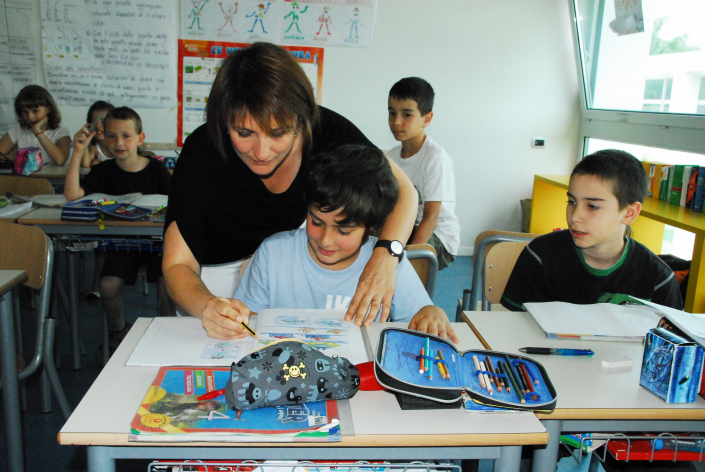 Un'insegnante a scuola aiuta un bambino a studiare