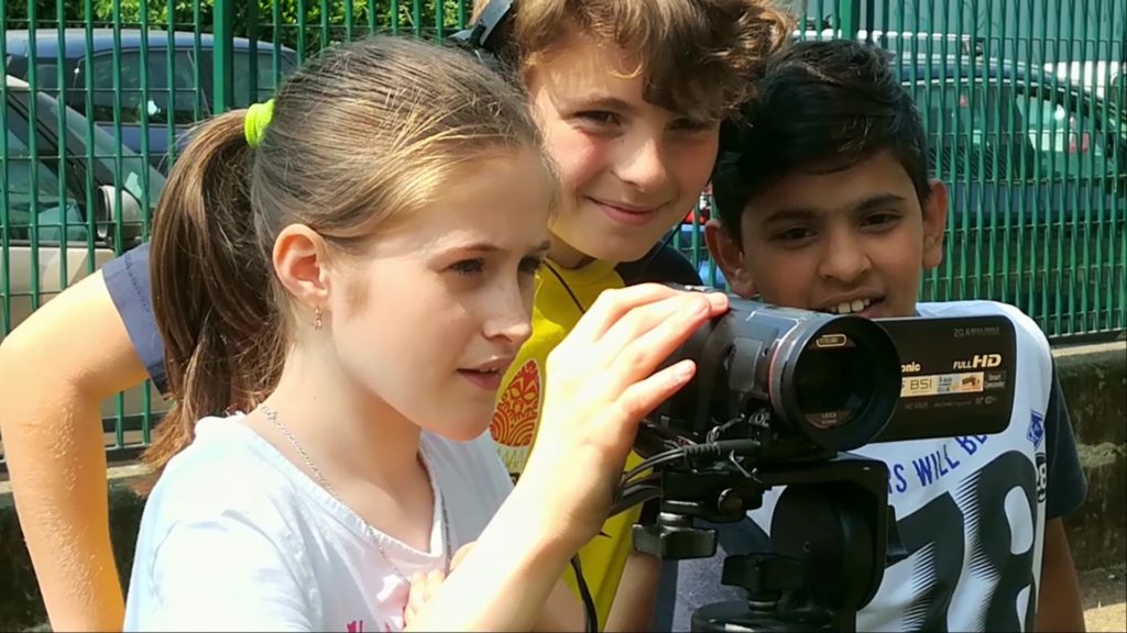 Un gruppo di bambini realizzare delle riprese con la telecamera