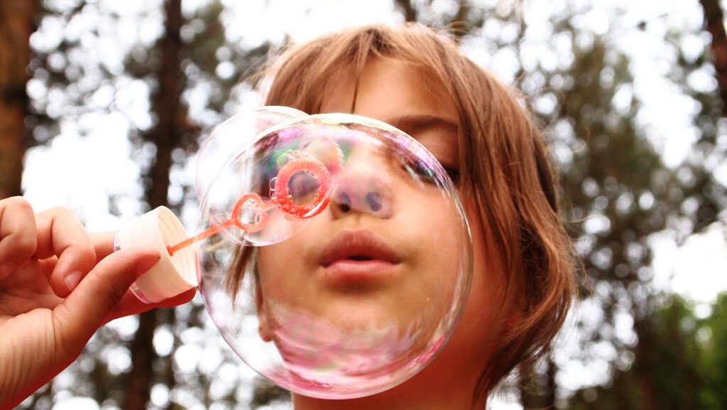 Una bambina gioca con le bolle di sapone