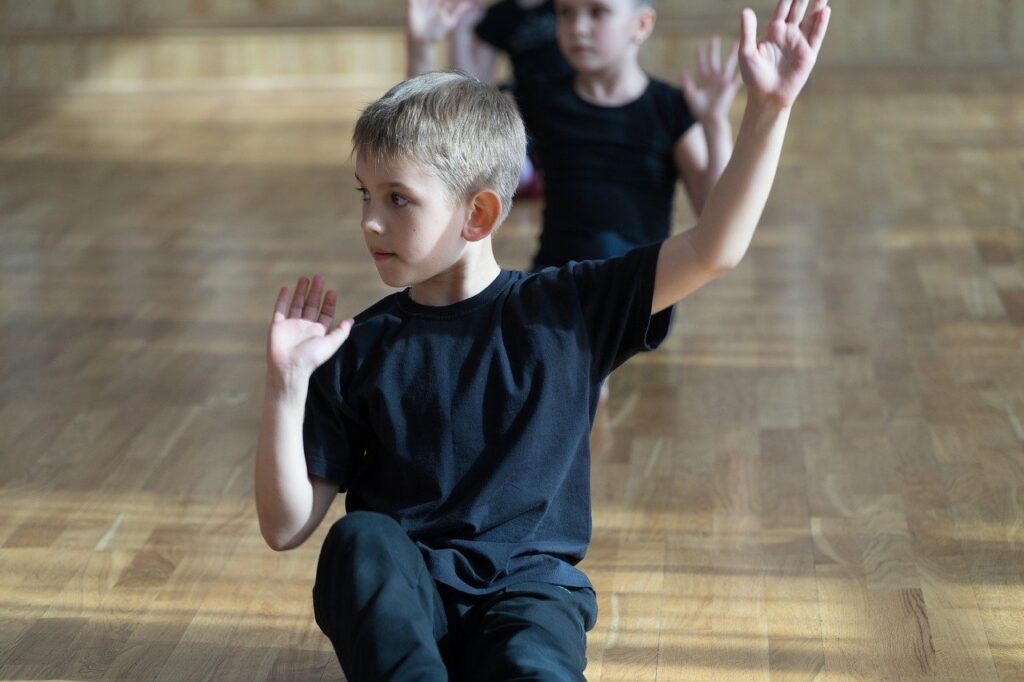 Bambini che si esercitano in palestra nell'espressione corporea