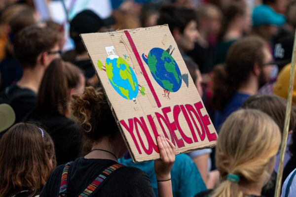 Un gruppo di ragazzi ad una manifestazione dei Fridays For Future, con un cartello ambientalista ("You decide")