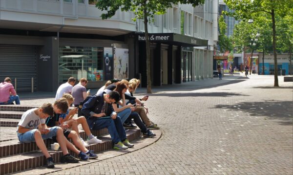 Un gruppo di ragazzini con lo smartphone, seduti su delle scale