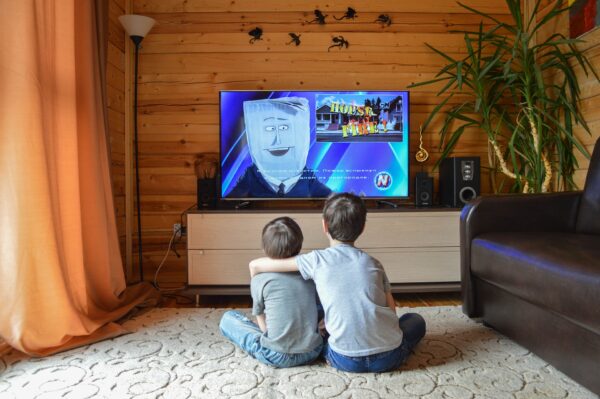 Due bambini davanti a uno schermo televisivo