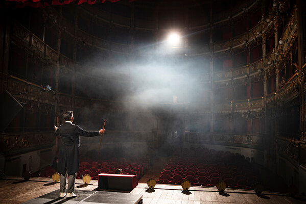 attore sul palco davanti a teatro vuoto