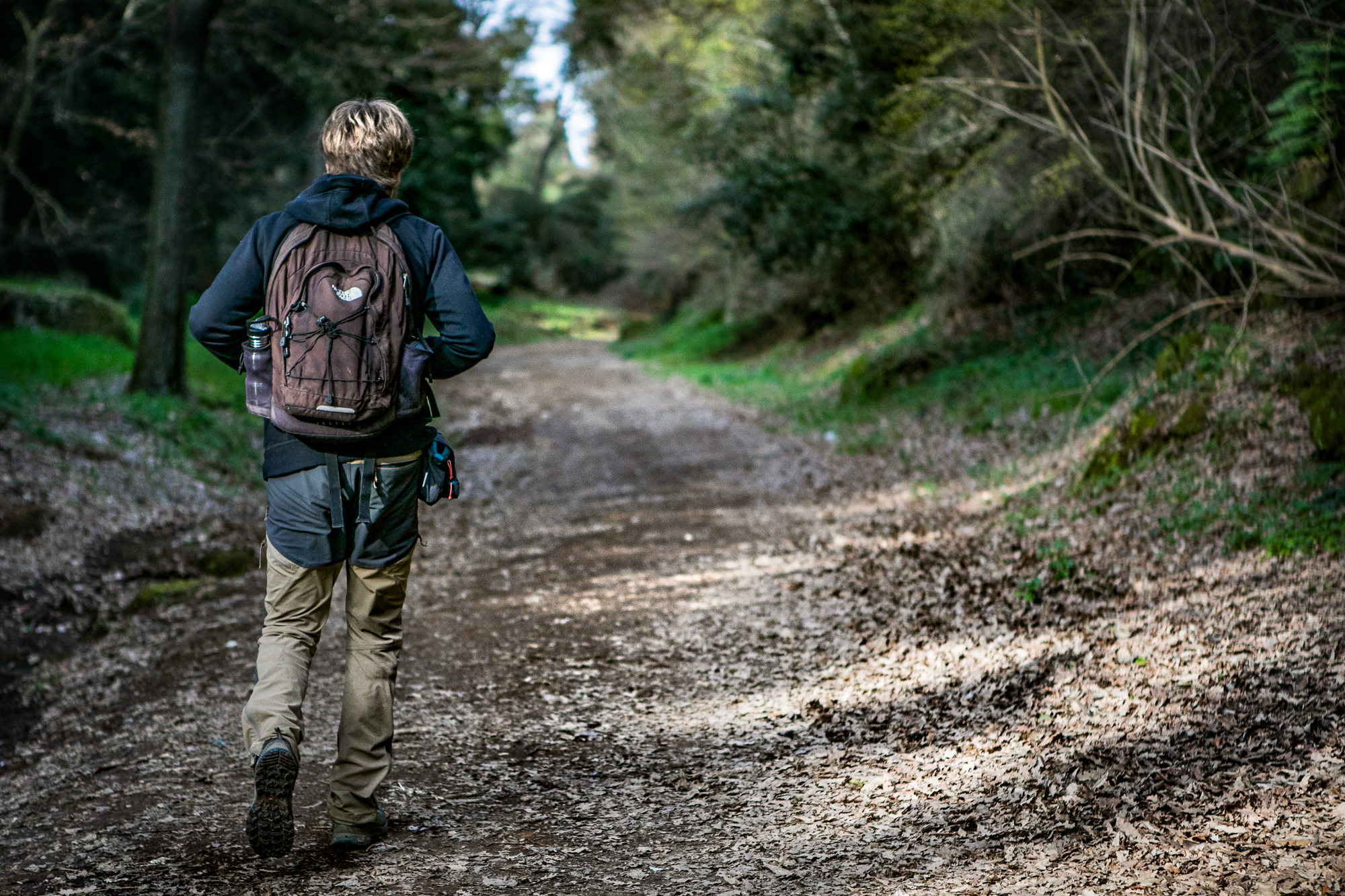 Un uomo di spalle fa trekking lungo la via Francigena in Tuscia