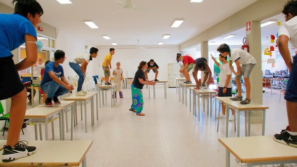 ragazzi in classe in piedi sui banchi, impegnati il attività (ri)creativa