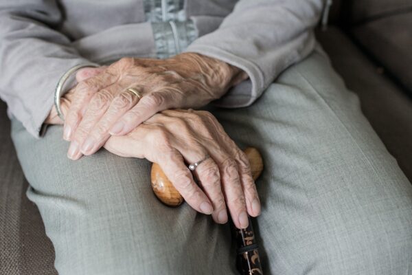 Dettaglio sulle mani di un'anziana, che stringono un bastone