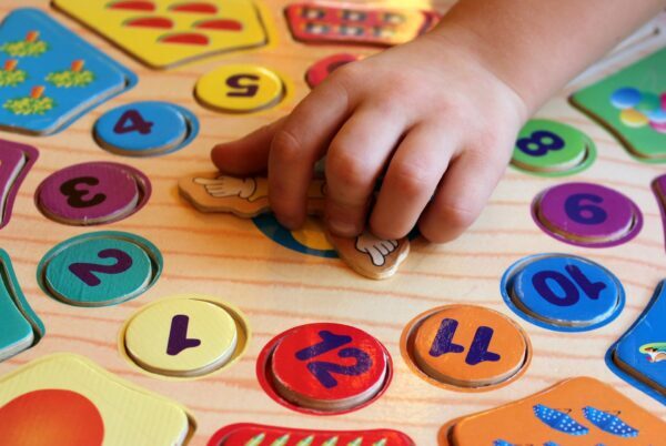 La mano di un bambino con dei numeri di cartone 